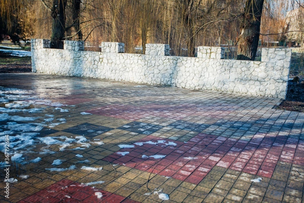 Fototapeta Nested pavers of various colors, around the grass is green, chic garden