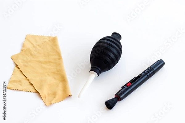 Obraz Camera lens cleaning kit with brush,pump and soft cloth on white surface