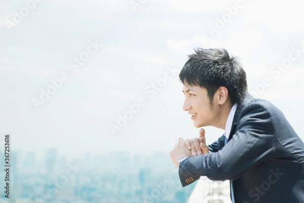 Obraz ビルの屋上で遠くを見るビジネスマン