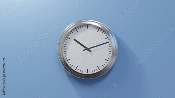 Fototapeta Glossy chrome clock on a blue wall at twelve past ten. Time is 10:12 or 22:12