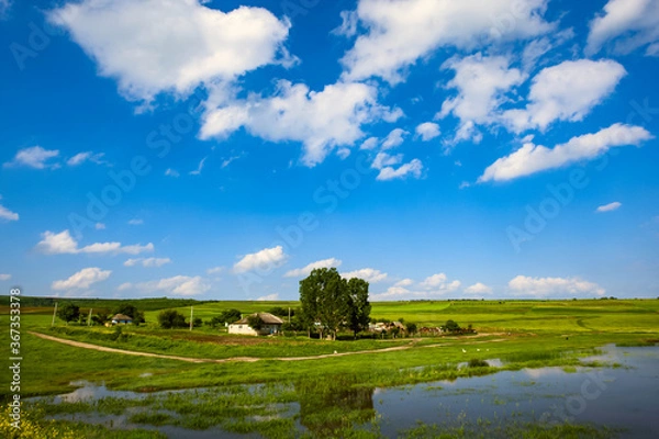 Fototapeta  A household outside of the village. A fabulous sky and clouds.