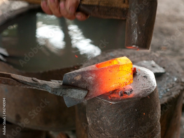 Fototapeta Blacksmith forging an ax