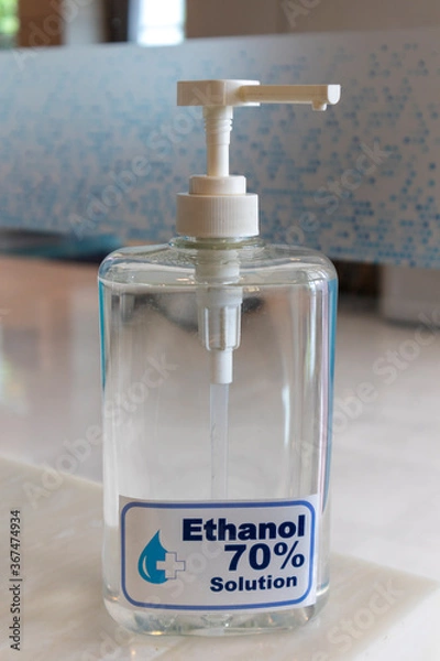 Fototapeta 70% ethyl alcohol in the bottle placed on wood table.