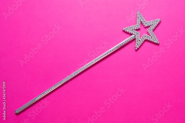 Fototapeta Sparkling magic wand on a pink background. Concept of celebration and magic, copy space.