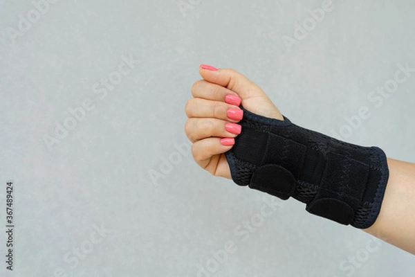 Obraz Close up of woman's hand wearing supportive orthopedic wrist brace in and copy space