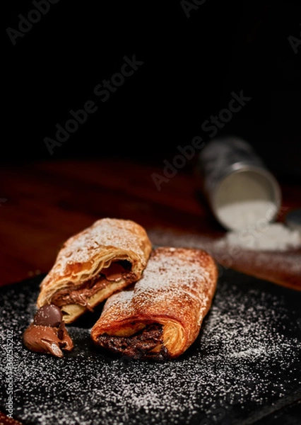 Fototapeta Freshly made chopped pastry with chocolate on black stone cutting board. Very shallow depth of field