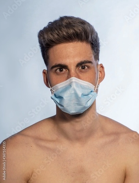 Fototapeta Shirtless Caucasian man wearing a medical mask for preventing the spread of COVID-19