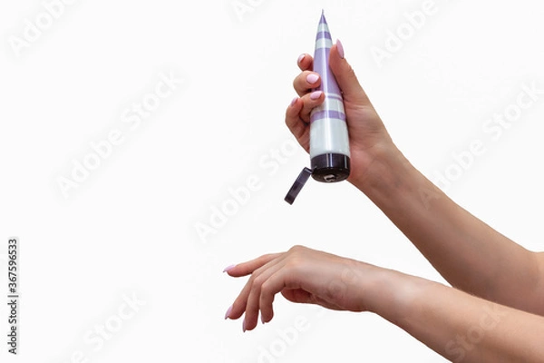 Obraz Close up of well-groomed female hands with a tube of cosmetic on the white tile background. Skincare and handcare concept. Cosmetic procedure.