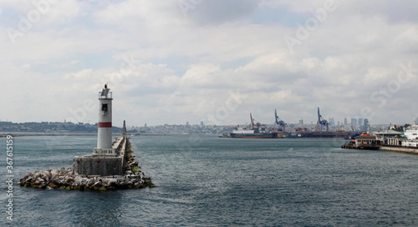Fototapeta Lighthouse in the Bosphorus. Breakwater in the Bosphorus. Mossy cliffs