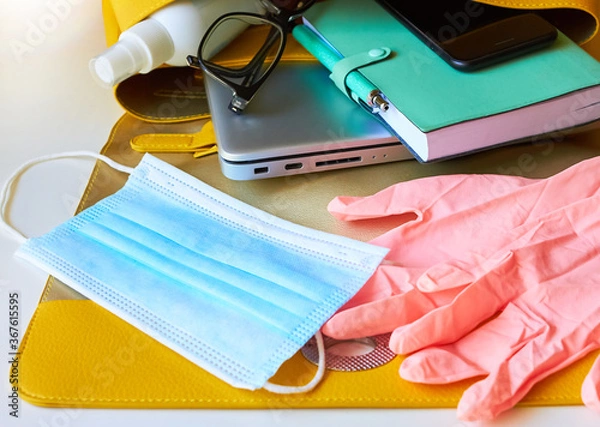 Fototapeta return to work, to office, to university, to study.new rules after covid-19. open women's bag: disposable gloves, protective mask, antiseptic, smartphone, notepad, glasses, laptop, wallet.