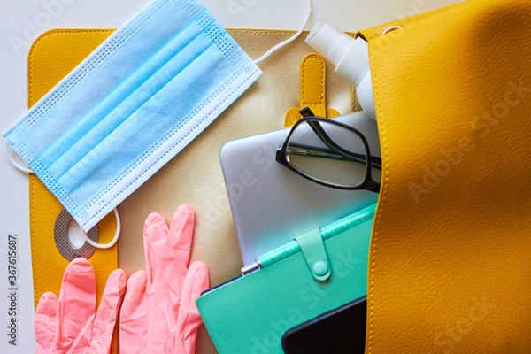 Fototapeta return to work, to office, to university, to study.new rules after covid-19. open women's bag: disposable gloves, protective mask, antiseptic, smartphone, notepad, glasses, laptop, wallet.