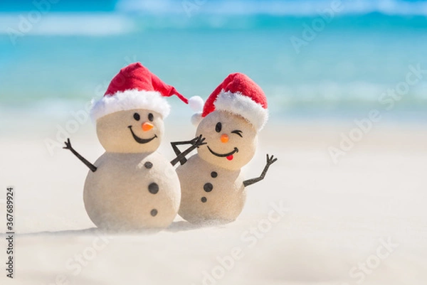 Obraz Two Sandy Christmas Snowmen are celebrating Christmas on a beautiful beach, the naughty one is in focus