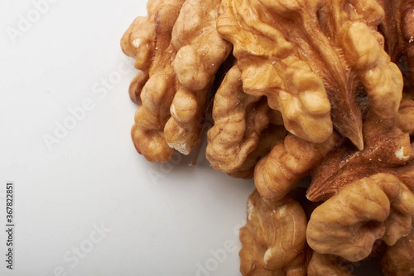 Obraz Walnut kernels on a wooden background.