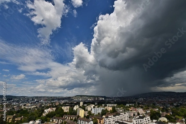 Fototapeta Heavy rain together over Zurich Switzerland with gray storm clouds and blue sky