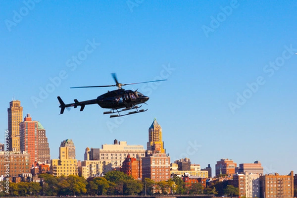 Obraz Black helicopter flies against the background of Brooklyn in the city of New York, USA
