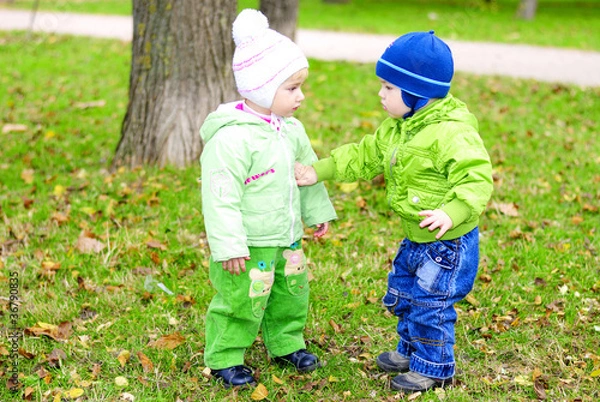 Fototapeta двое малышей играют на зеленой полянке