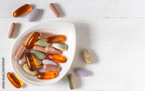 Obraz Variety of vitamin pills on white wooden background, supplemental and healthcare product, flat lay surface