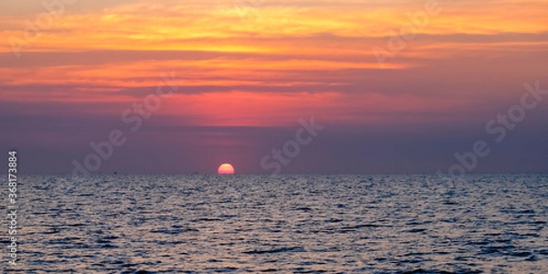 Fototapeta Sunset over the ocean Peaceful seascape. Beautiful cloudy sky over calm sea with sunlight reflection. Copy space banner.