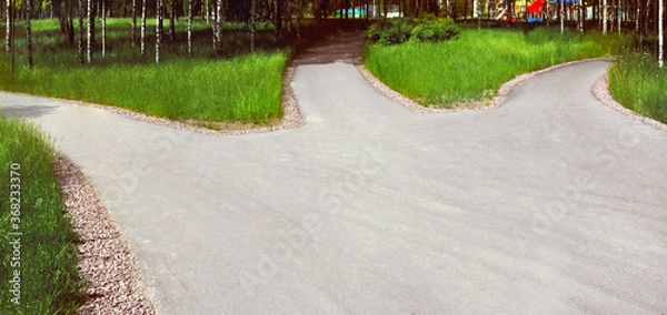 Obraz Divergence of paths: a wide asphalt road in the park is divided into three alleys, diverging in different directions