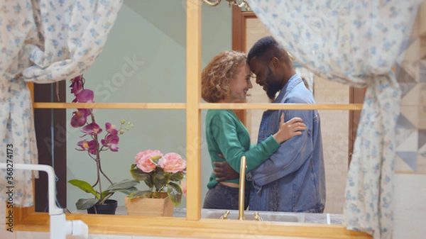 Obraz View through window of lovely diverse couple hugging shopping in modern furniture store