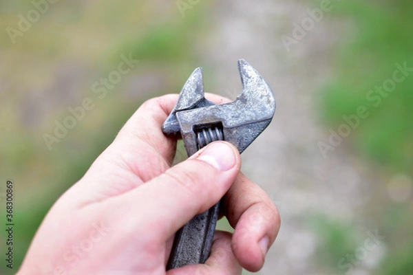 Fototapeta A small shiny wrench in the hands of the master