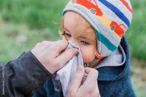 Obraz Man wiping toddler’s nose