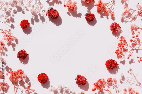 Fototapeta Red flower layout. Dry flowers arranged on paper. An empty space for the text in the center. Flat lay design.