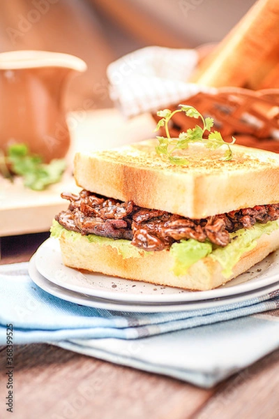 Fototapeta A Plate of Grilled Beef Sandwich on a Blue Napkin