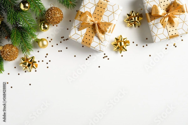 Fototapeta Christmas flat lay composition. Top view gold pine tree branch, Xmas decorations, golden balls and gift boxes on white background. Christmas, winter, New Year concept.