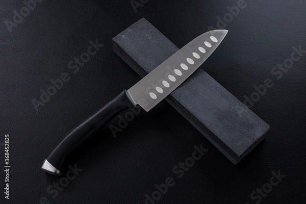 Obraz The knife with whetstone on Leather background.