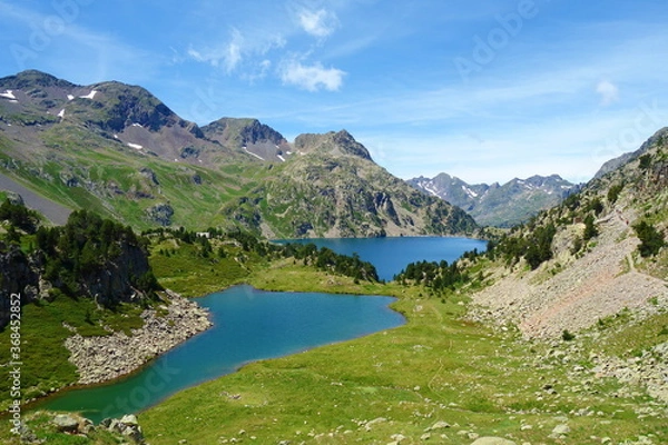 Fototapeta Respumoso dam (Embalse de Respumoso) among barren rocky mountains with snow and blue sky in a sunny summer in Panticosa, Aragon Pyrenees, Spain