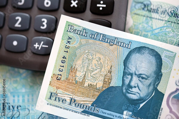 Fototapeta British Currency. The new UK polymer five pound note with a calculator. 