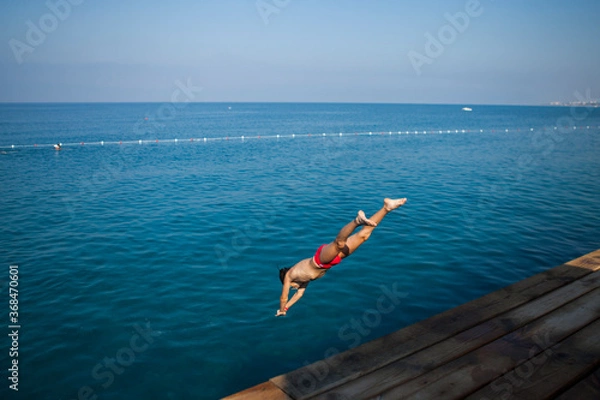Obraz The boy jumped from the pier into the sea