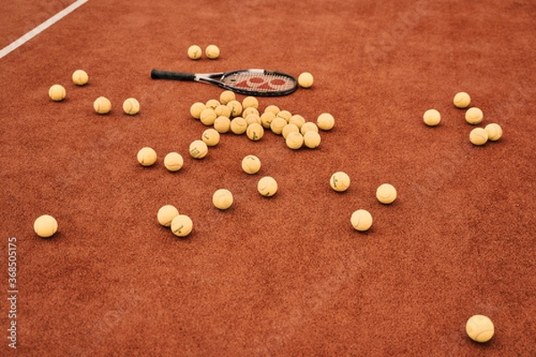 Obraz Tennis balls scattered around the court