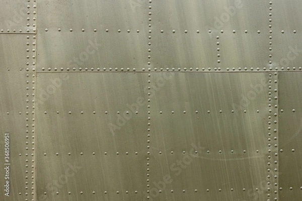 Obraz Details of the fuselage of an old aircraft. Old camouflage surface with exfoliated paint and rivets on a military aircraft.