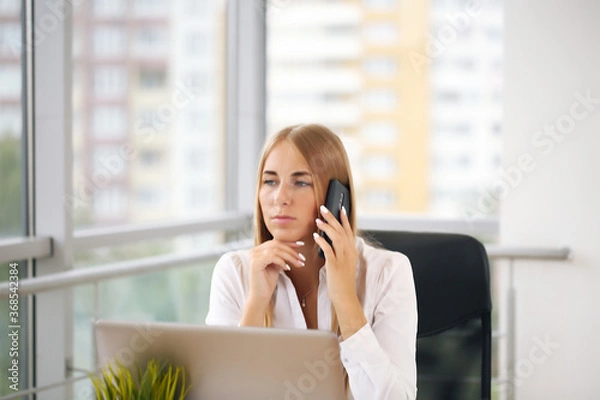 Fototapeta Focused woman working at her computer. Background for office startup