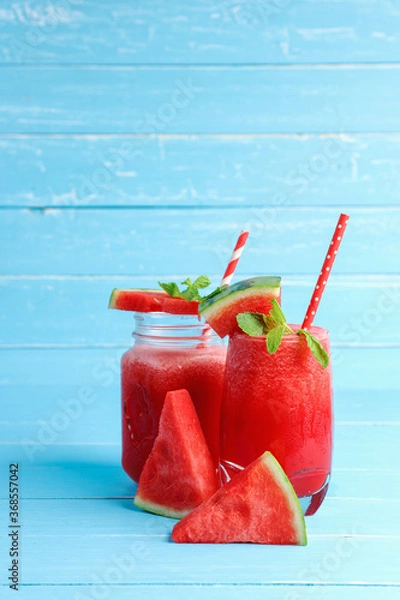 Fototapeta Watermelon smoothie drinks in the glass on blue wooden background with copy space.