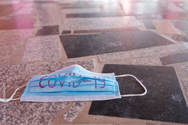 Fototapeta The medical masks used for the protection against COVID-19 left on the road. 