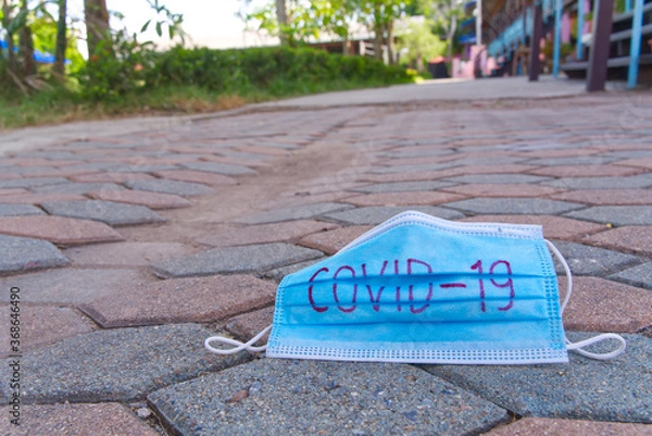 Fototapeta The medical masks used for the protection against COVID-19 left on the road. 