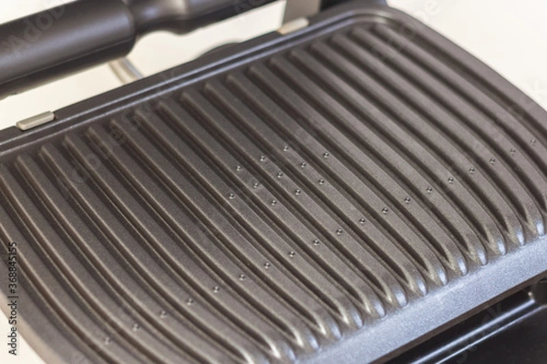 Fototapeta Ridge teflon surface of an electric grill. Close-up view of barbecue for home use.