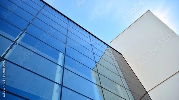 Fototapeta Abstract image of looking up at modern glass and concrete building. Architectural exterior detail of office building. Industrial art and detail.