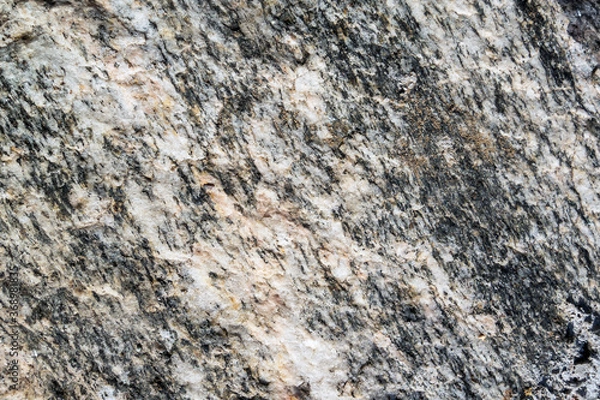 Fototapeta Close up view onto rough surface of split granite stone with its granular and phaneritic in texture