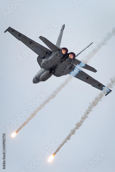 Obraz Fighter jet aircraft firing countermeasures flares to avoid missiles.