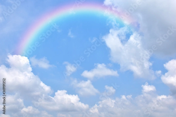 Fototapeta Abstract rainbow on beautiful blue sky and white clouds as background and wallpaper. 