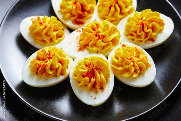 Obraz Easter party snack deviled eggs on a black plate