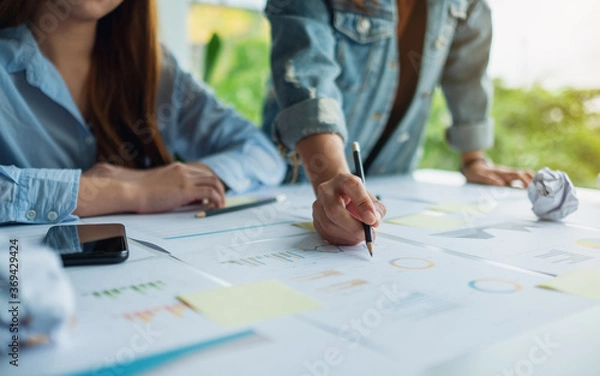 Fototapeta Group of businessman discussing and  working on financial paperwork in the office