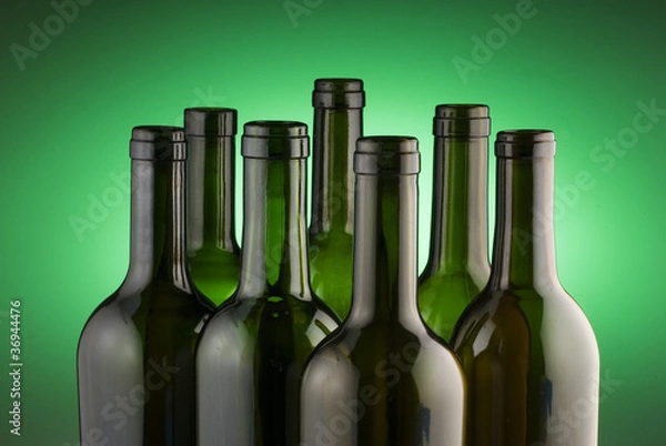 Obraz Red wine bottles back lit by a green spot light