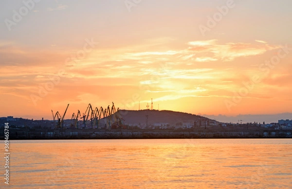 Fototapeta View of silhouettes of cranes and a hill against the sky