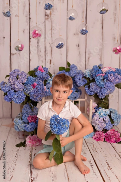 Obraz Happy baby boy in the studio on a white background with pink and blue hydrangea flowers
