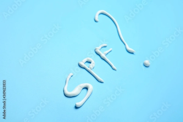 Obraz SPF written with sunscreen cream on color background